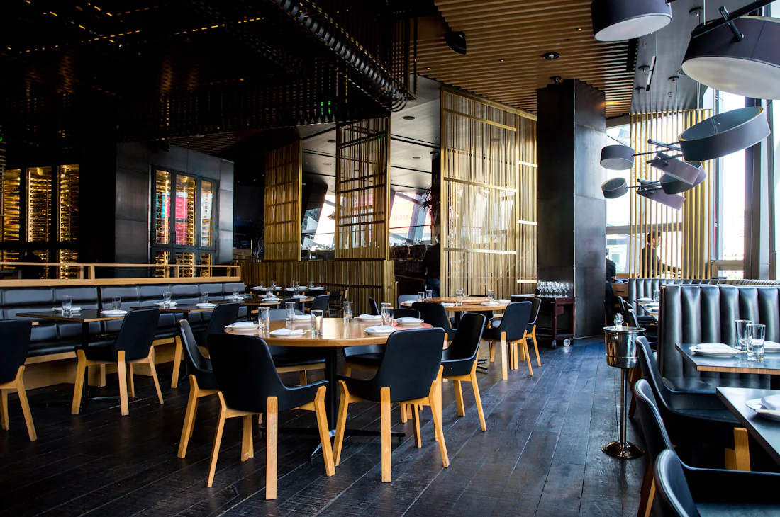 Warm dining room with dark wood tables and brass details